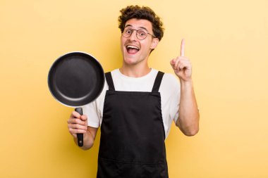 Genç yakışıklı bir adam bir fikri fark ettikten sonra mutlu ve heyecanlı bir dahi gibi hissediyor. Şefin tava konsepti.