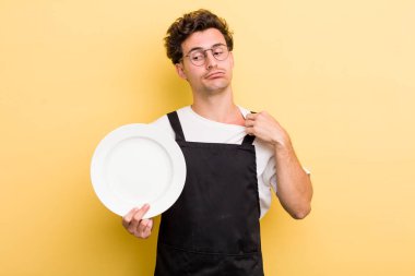 Genç yakışıklı, stresli, endişeli, yorgun ve hayal kırıklığına uğramış hissediyor. boş tabak kavramı