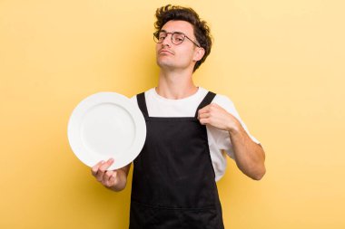 Genç yakışıklı adam kibirli, başarılı, pozitif ve gururlu görünüyor. boş tabak kavramı