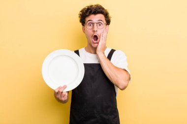 Genç ve yakışıklı adam şok olmuş ve korkmuş hissediyor. boş tabak kavramı
