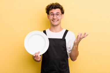 Genç yakışıklı adam kendini mutlu hissediyor, bir çözüm ya da fikir bulduğuna şaşırıyor. boş tabak kavramı