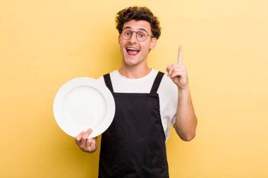 Genç yakışıklı bir adam bir fikri fark ettikten sonra mutlu ve heyecanlı bir dahi gibi hissediyor. boş tabak kavramı