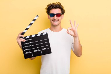 Genç yakışıklı adam kendini mutlu hissediyor, iyi bir jestle onaylıyor. film konsepti