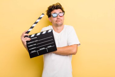 Genç yakışıklı adam omuz silkiyor, kafası karışık ve kararsız hissediyor. film konsepti