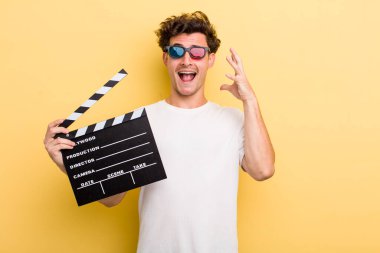 Genç yakışıklı adam ellerini havaya kaldırarak çığlık atıyor. film konsepti