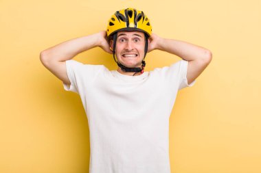 Genç ve yakışıklı adam stresli, endişeli ya da korkmuş, elleri başının üstünde. Bisiklet konsepti motor konsepti