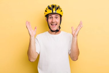 Genç yakışıklı adam kendini mutlu hissediyor ve inanılmaz bir şeye hayret ediyor. Bisiklet konsepti motor konsepti