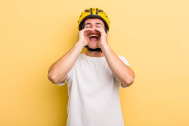 Genç yakışıklı adam kendini mutlu hissediyor, elleri ağzının kenarında bağırıyor. Bisiklet konsepti motor konsepti