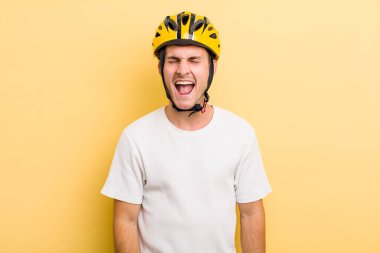 Genç yakışıklı adam agresif bir şekilde bağırıyor, çok kızgın görünüyor. Bisiklet konsepti motor konsepti