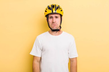 Genç yakışıklı üzgün ve ağlayan mutsuz bakışlı bir adam. Bisiklet konsepti motor konsepti