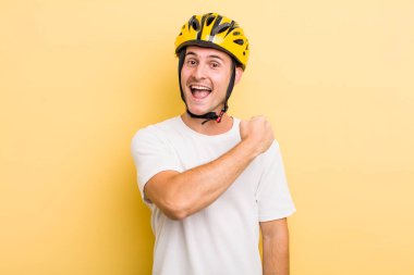 Genç yakışıklı adam kendini mutlu hissediyor ve bir meydan okumayla yüzleşiyor ya da kutluyor. Bisiklet konsepti motor konsepti