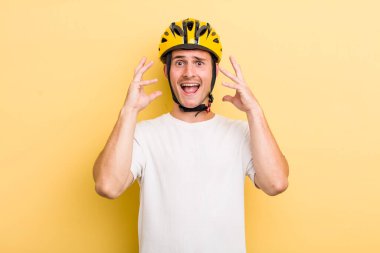 Genç yakışıklı adam ellerini havaya kaldırarak çığlık atıyor. Bisiklet konsepti motor konsepti