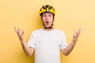Genç ve yakışıklı adam şok olmuş ve şaşırmış hissediyor. Bisiklet konsepti motor konsepti