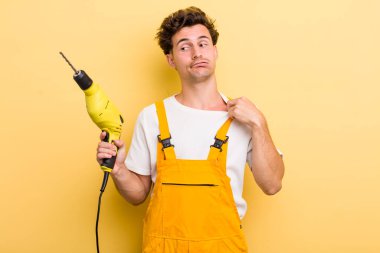 Genç yakışıklı, stresli, endişeli, yorgun ve hayal kırıklığına uğramış hissediyor. Matkap konsepti olan bir tamirci.