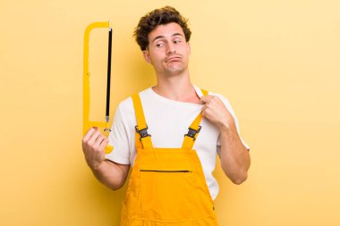 Genç yakışıklı, stresli, endişeli, yorgun ve hayal kırıklığına uğramış hissediyor. Tamirci ve testere konsepti