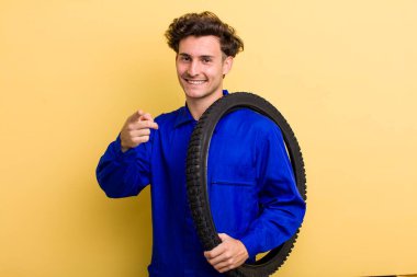 Genç ve yakışıklı bir adam kamerayı işaret ederek seni seçiyor. motor mekaniği kavramı