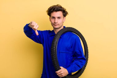 Genç ve yakışıklı adam kendini kötü hissediyor, baş parmağını kaldırıyor. motor mekaniği kavramı