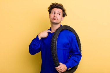 Genç yakışıklı, stresli, endişeli, yorgun ve hayal kırıklığına uğramış hissediyor. motor mekaniği kavramı