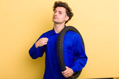 Genç yakışıklı adam kibirli, başarılı, pozitif ve gururlu görünüyor. motor mekaniği kavramı