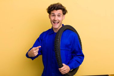 Genç yakışıklı adam heyecanlı ve şaşırmış görünüyor. motor mekaniği kavramı