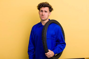 Genç yakışıklı üzgün ve ağlayan mutsuz bakışlı bir adam. motor mekaniği kavramı