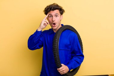 Genç yakışıklı adam şaşırmış görünüyor, yeni bir düşünce, fikir ya da konsept fark ediyor. motor mekaniği kavramı