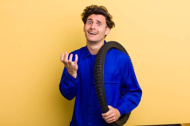 Genç ve yakışıklı adam umutsuz, sinirli ve stresli görünüyor. motor mekaniği kavramı