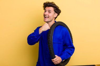 Genç yakışıklı adam kendini mutlu hissediyor ve bir meydan okumayla yüzleşiyor ya da kutluyor. motor mekaniği kavramı