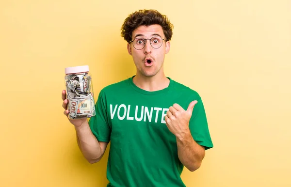 若いハンサムな男が不信に驚いている 寄付とボランティアのコンセプト — ストック写真