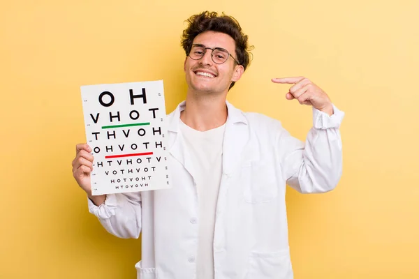 young handsome guy smiling confidently pointing to own broad smile. optical vision test concept