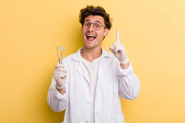 アイデアを実現した後 幸せで興奮した天才のように感じる若いハンサムな男 歯科医のコンセプト — ストック写真