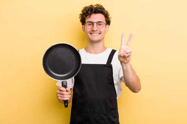 Joven Chico Guapo Sonriendo Buscando Amigable Mostrando Número Dos Chef — Foto de Stock