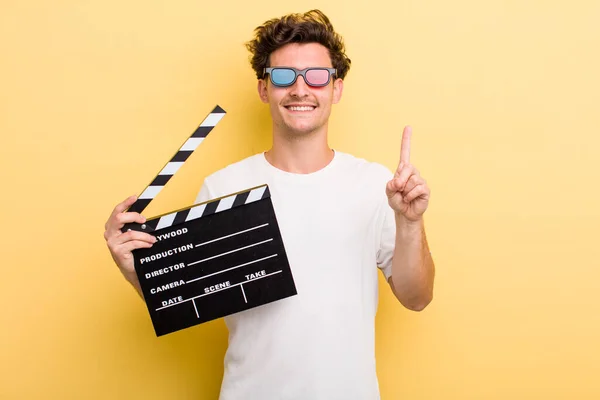 Young Handsome Guy Smiling Looking Friendly Showing Number One Movie — Stockfoto