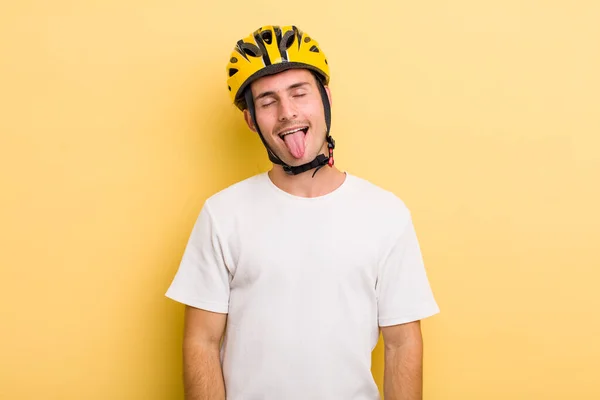 陽気で反抗的な態度を持つ若いハンサムな男冗談と舌を突き出す 自転車のコンセプト 自転車のコンセプト — ストック写真