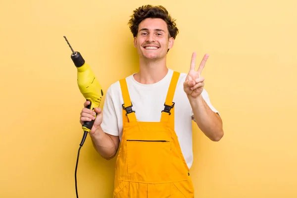 Jovem Cara Bonito Sorrindo Olhando Feliz Gesticulando Vitória Paz Faz — Fotografia de Stock