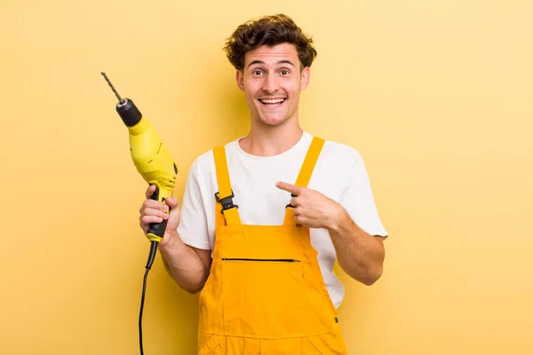 Young Handsome Guy Feeling Happy Pointing Self Excited Handyman Drill — Stockfoto