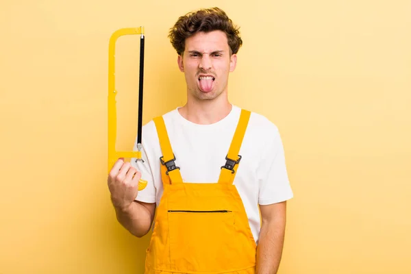 Young Handsome Guy Feeling Disgusted Irritated Tongue Out Handyman Saw — Stock Photo, Image