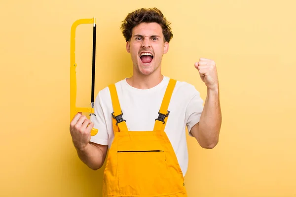 Young Handsome Guy Shouting Aggressively Angry Expression Handyman Saw Concept — Stock Photo, Image