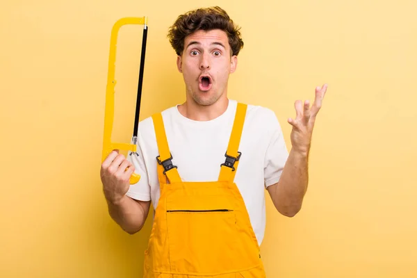 Young Handsome Guy Feeling Extremely Shocked Surprised Handyman Saw Concept — Stock Photo, Image