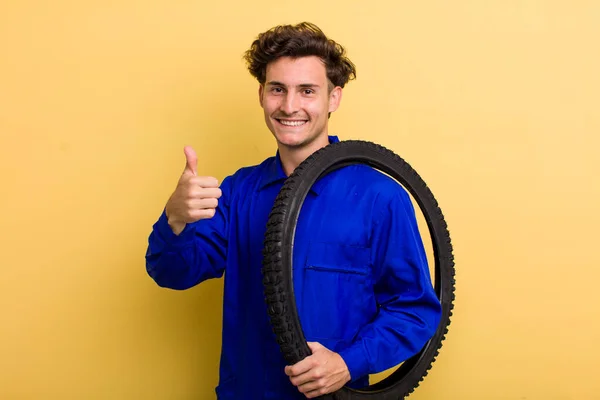 若いハンサムな男は誇りを感じ 親指を上げて積極的に笑顔 自転車整備士のコンセプト — ストック写真