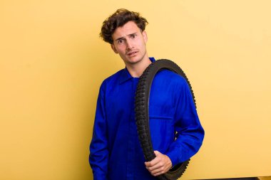 Genç yakışıklı adam şaşkın ve şaşkın hissediyor. motor mekaniği kavramı