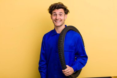 Genç yakışıklı adam mutlu ve hoş bir şekilde şaşırmış görünüyor. motor mekaniği kavramı