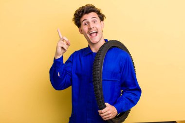 Genç yakışıklı bir adam bir fikri fark ettikten sonra mutlu ve heyecanlı bir dahi gibi hissediyor. motor mekaniği kavramı