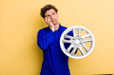 young handsome teenager feeling bored, frustrated and sleepy after a tiresome. car mechanic concept