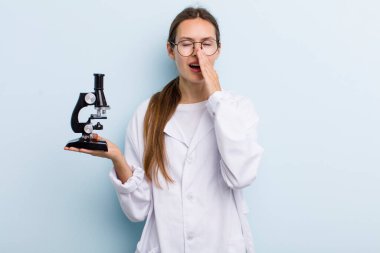 Genç, yetişkin bir kadın kendini mutlu hissediyordu. Elleri ağzının kenarında bağırıyordu. Mikroskoplu bir bilim adamı