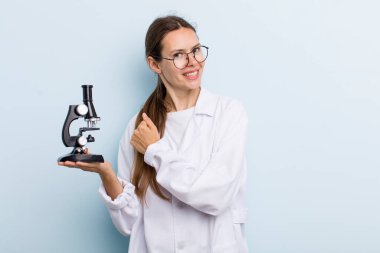 Genç yetişkin bir kadın kendini mutlu hissediyor ve bir meydan okumayla yüzleşiyor ya da kutluyor. Mikroskoplu bir bilim adamı