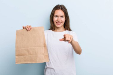 Genç yetişkin bir kadın kamerayı işaret ederek seni seçiyor. teslimat ve paket konsepti