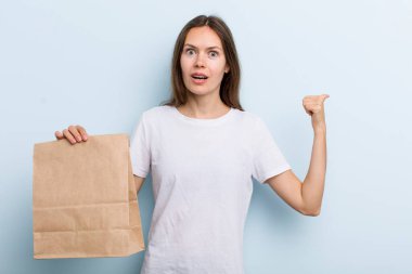 İnançsızlığa şaşırmış genç bir kadın. teslimat ve paket konsepti