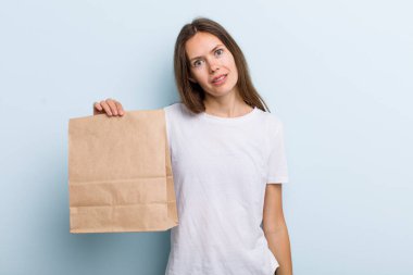 Genç bir kadın şaşkın ve şaşkın hissediyor. teslimat ve paket konsepti