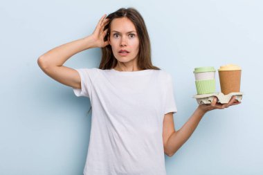 Genç bir kadın stresli, endişeli ya da korkmuş hissediyor. Elleri başının üstünde. kahve konseptini kaldır.